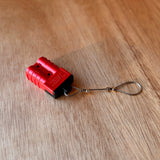 Red Anderson-style plug fitted with a black TPU dust cover and stainless steel wire tether